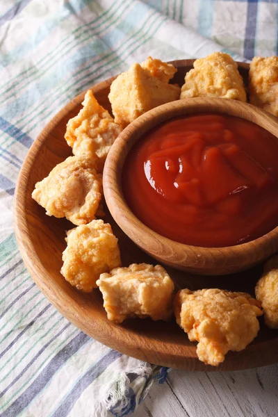 Fast food: crispy popcorn chicken with sauce close-up. vertical