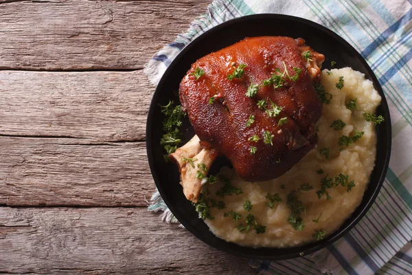 Baked knuckle and mashed potatoes closeup. horizontal top view