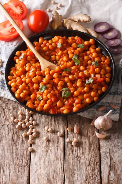 Indian cuisine: Chana masala with ingredients close-up. vertical