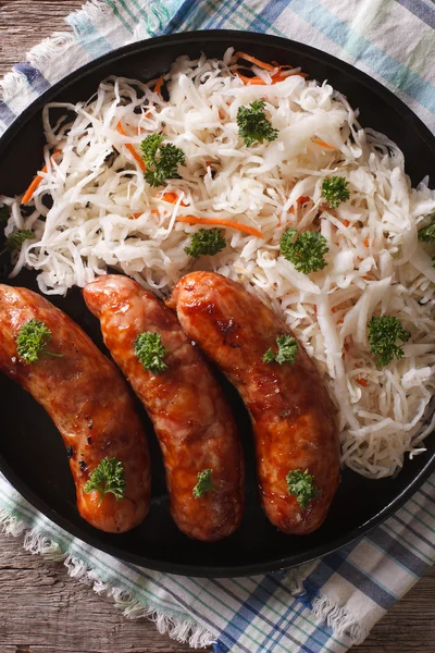 Grilled sausages and sauerkraut close-up. vertical top view