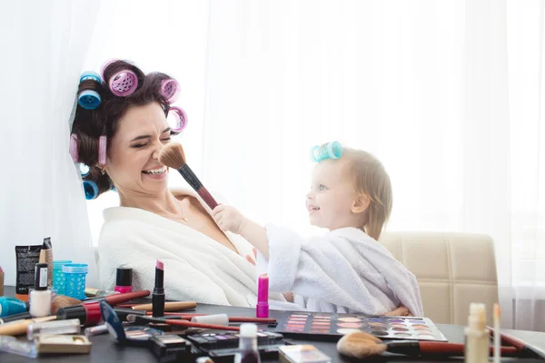 Mother and daughter are doing hair, manicures, makeup, having fun.