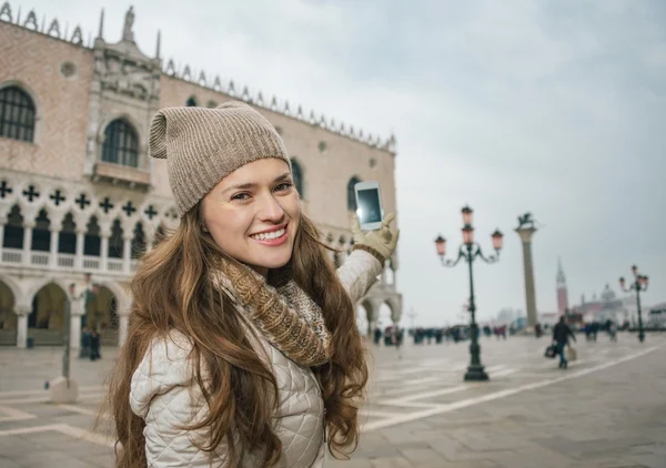 Happy young woman tourist taking photos on St. Mark\'s Square