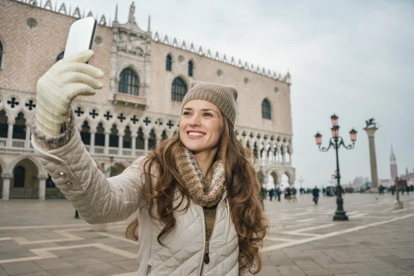 Woman tourist taking selfie with cell phone on St.Mark\'s Square