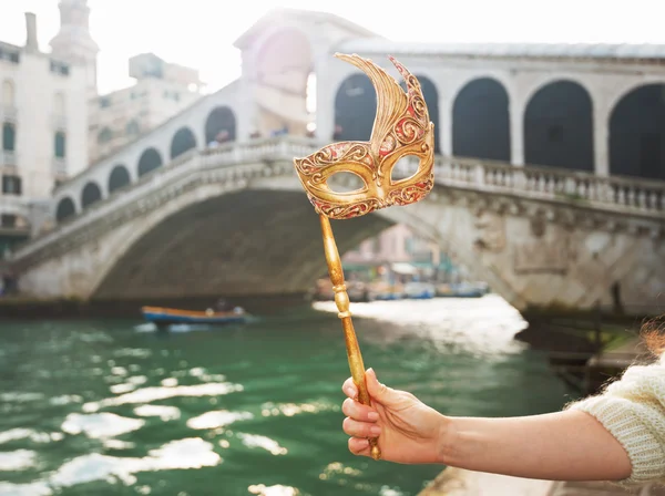 Closeup on woman hand holding Venice Mask near Rialto Bridge