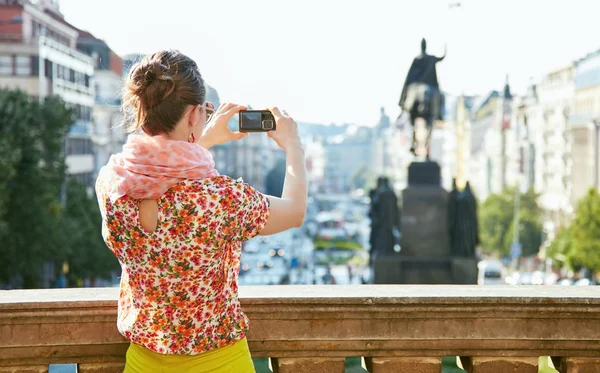 Seen from behind woman taking photos with camera in Prague