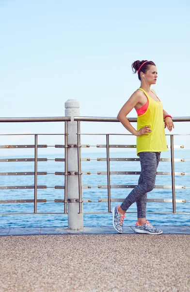 Fitness woman looking into distance and listening to the music