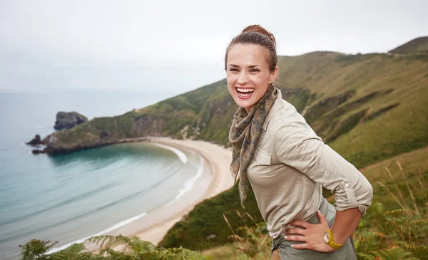 Happy adventure woman hiker in front of ocean view landscape