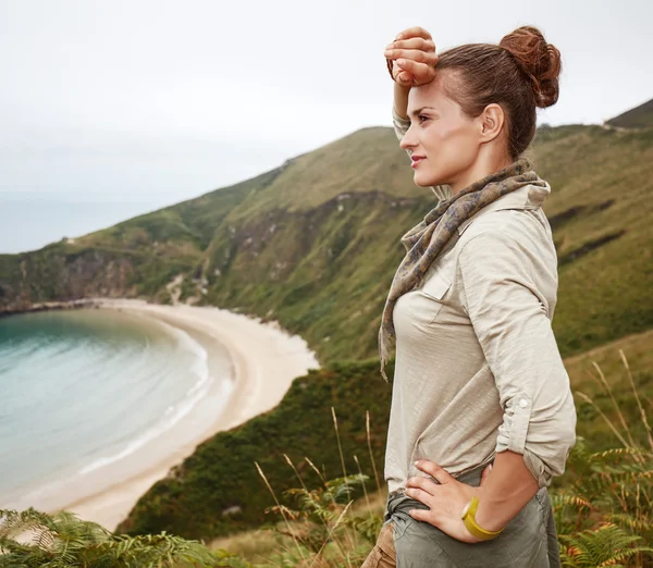 Woman looking into distance in front of ocean view landscape