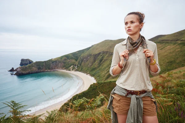 Adventure woman hiker in front of ocean view landscape