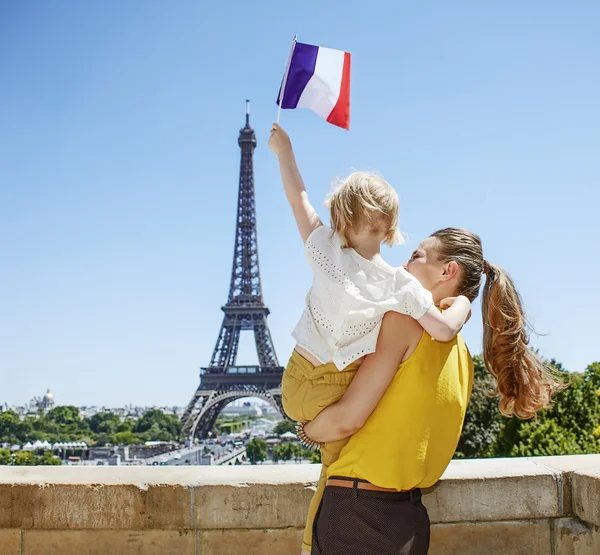 Mother and child travellers rising flag in Paris, France