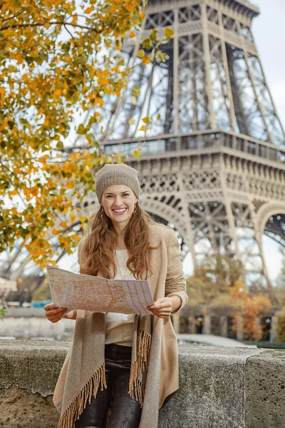 Tourist woman on embankment near Eiffel tower in Paris with map