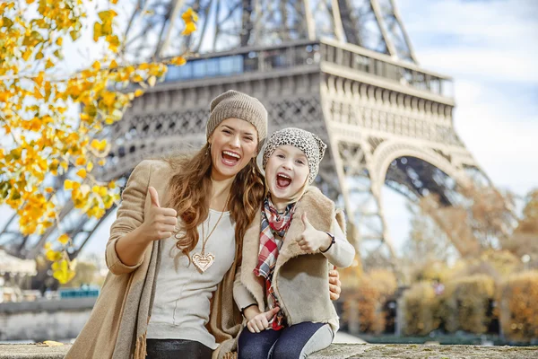 Mother and child travellers in Paris, France showing thumbs up