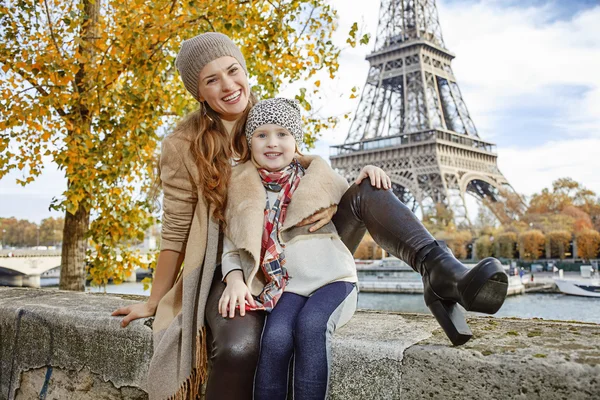 Mother and daughter travellers sitting on the parapet in Paris