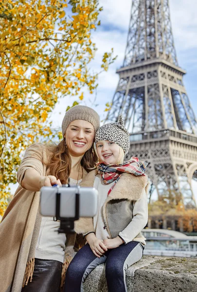 Smiling mother and daughter travellers taking selfie in Paris