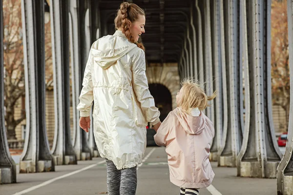 Active mother and daughter on Pont de Bir-Hakeim bridge walking