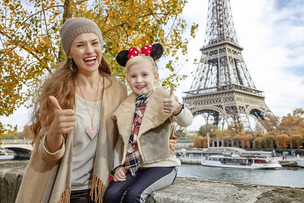 Mother and girl in Minnie Mouse Ears showing thumbs up, Paris