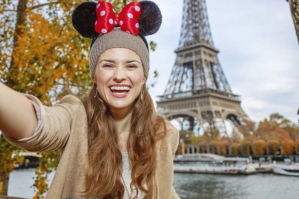Tourist woman wearing Minnie Mouse Ears taking selfie in Paris