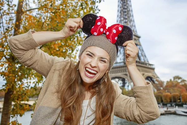 Tourist woman wearing Minnie Mouse Ears on embankment in Paris