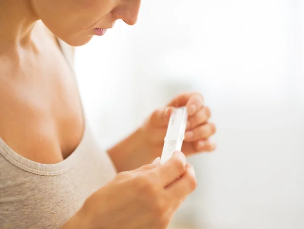 Closeup on young woman looking on pregnancy test