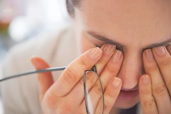 Closeup on tired business woman with eyeglasses