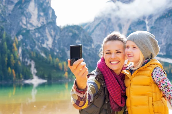 Happy mother and baby making selfie on lake braies in south tyro