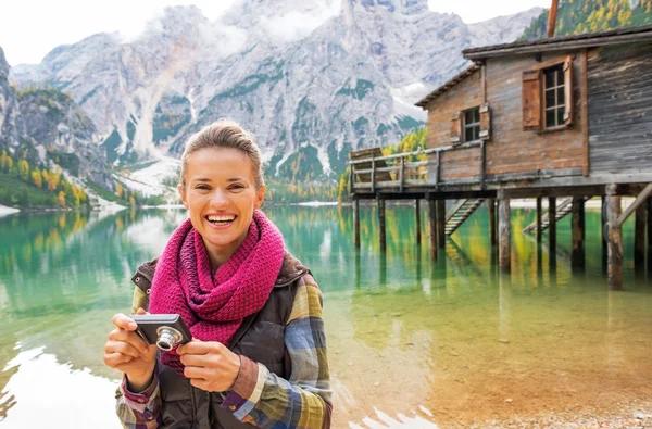 Portrait of young woman with photo camera on lake braies in sout