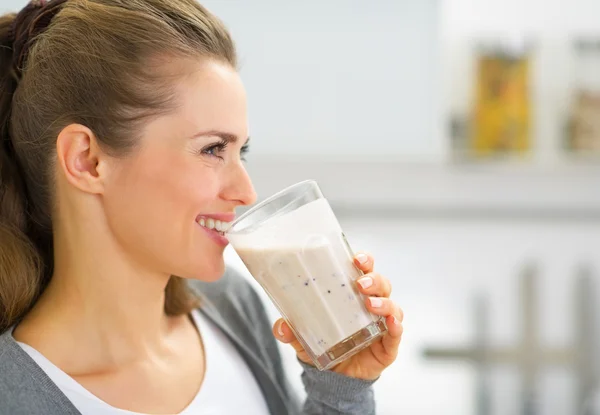 Profile portrait of happy young woman drinking fresh smoothie
