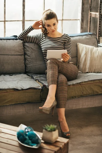 Young stylish woman puzzled with something holding tablet