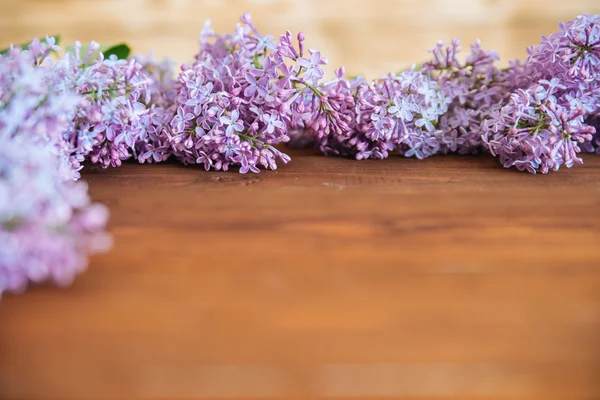 Bunch of lilac flowers on wood table