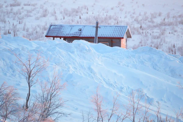 Avalanche. A hut under snow. Blizzard in the cold winter.