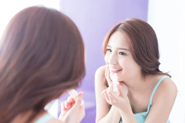 woman putting   lip balm on lips