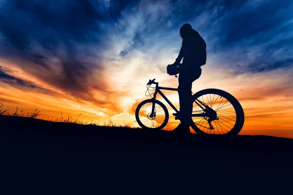 Silhouette of bicyclist preparing for the trail run in the mountains