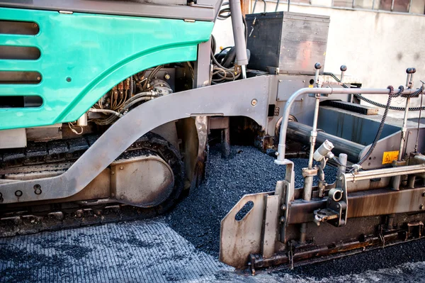 Industrial pavement truck or machine laying fresh bitumen and asphalt