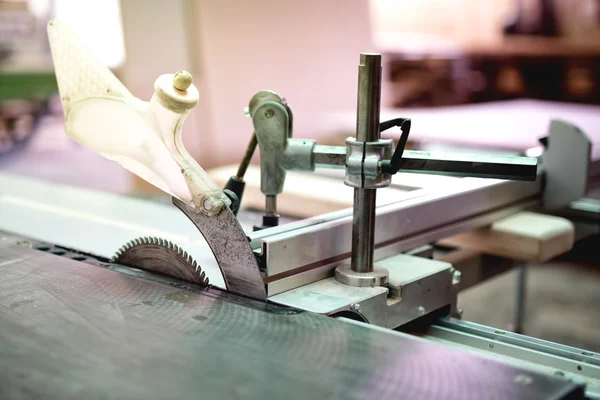 Industrial circular compound mitre saw cutting timber and wooden boards at local industrial factory