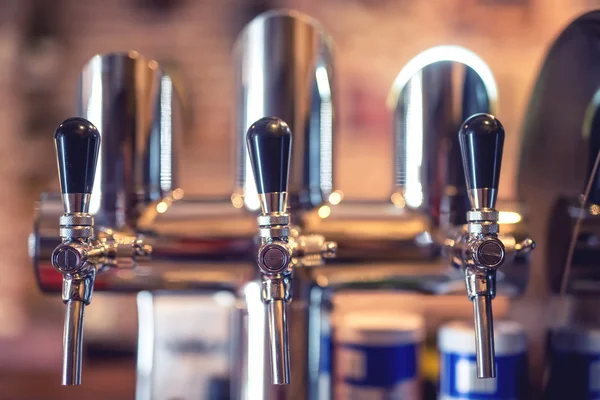 Beer tap at restaurant, bar or pub. Close-up details of beer draft taps in a row