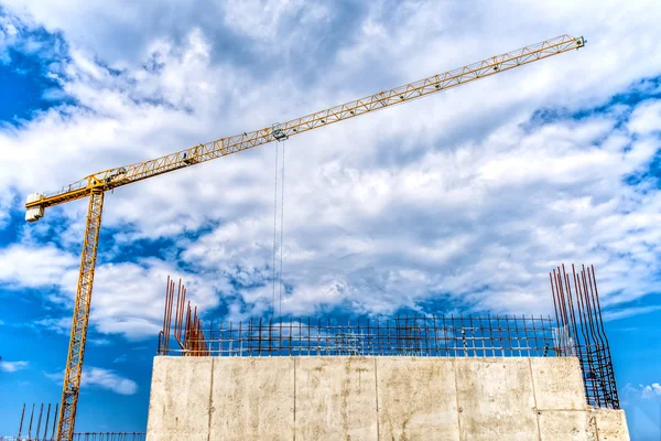 Industrial construction site with huge, mega crane and reinforced steel concrete walls closeup