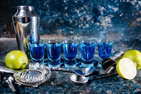 Blue curacao shots, alcoholic strong drinks. Cocktails and garnish at bar, pub or restaurant