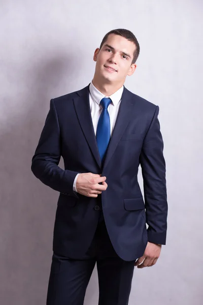 A handsome young man smiling pretty brunette in a dark business suit. Business portrait. business style. office. on a white background