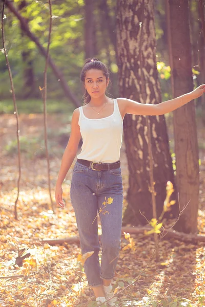 Beautiful young girl walking and having fun in the warm autumn park among yellow leaves. Moscow, Sokolniki. Indian summer.