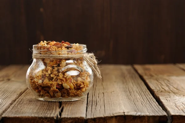 Granola in jar with packing-twine on wooden background with spac