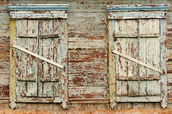 Two old wooden windows with closed shutters