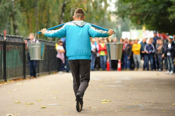 Orel, Russia, September 5, 2015: Boy carrying two bucket of wate