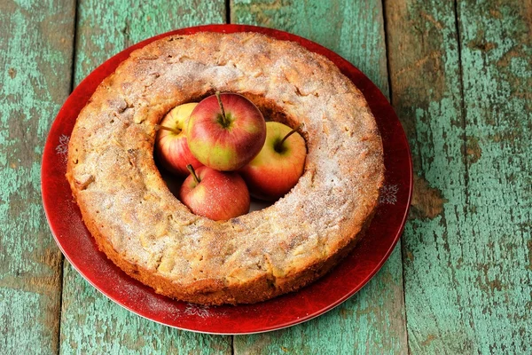 Homemade round apple cake with fresh red apples in the middle