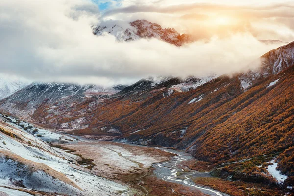 Mountain landscape of snow-capped mountains in the mist.