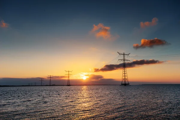 Electric line above water during a fantastic sunset.