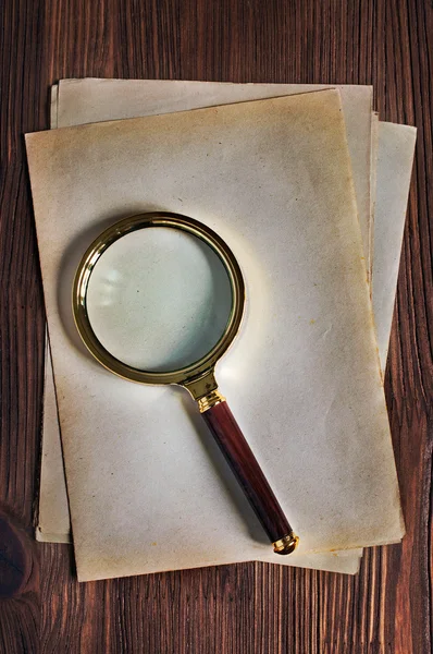 Magnifying glass and old yellowed sheet of paper