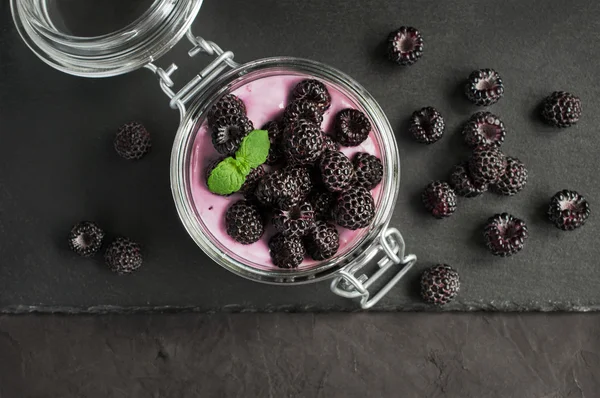 Yogurt with black raspberry or blackberry in glass jar