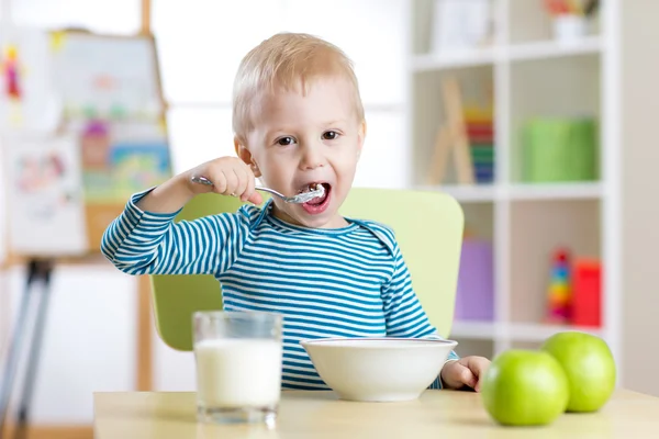 Child eats healthy food at home or kindergarten