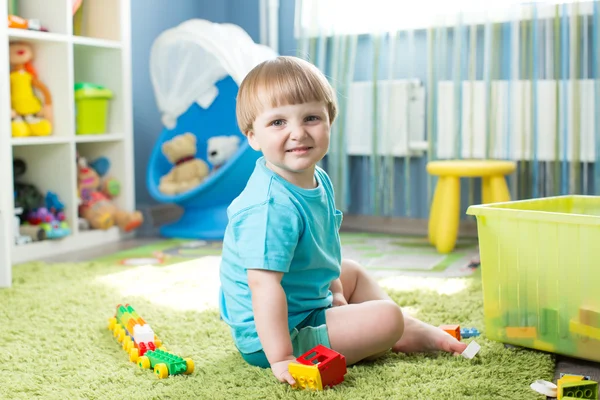 Kid playing with building blocks at home or kindergarten