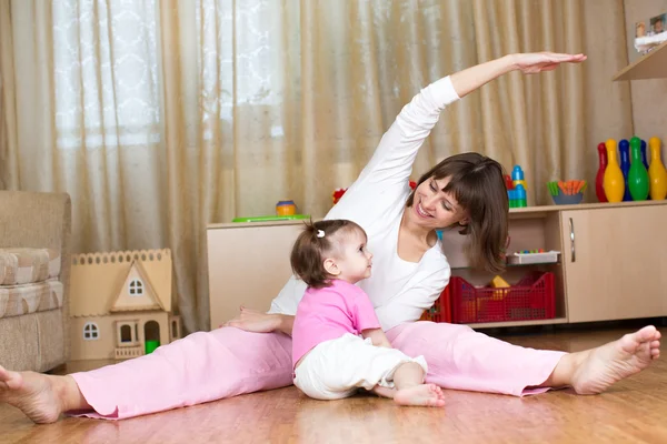 Mother and kid doing gymnastic at home